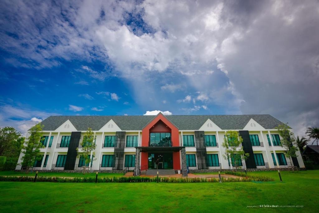 a large white building with a red roof at Malangpor Hotel in Phayao