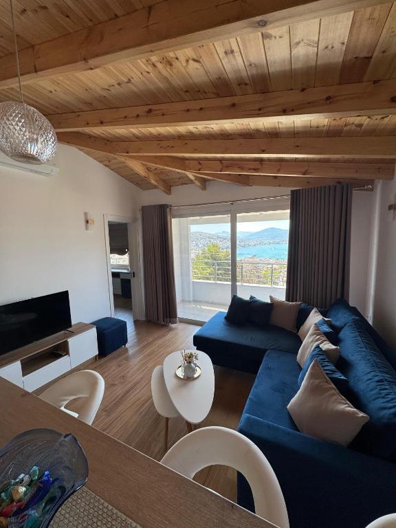 a living room with a blue couch and a table at Vitamine Luxury Apartments 2 in Sarandë