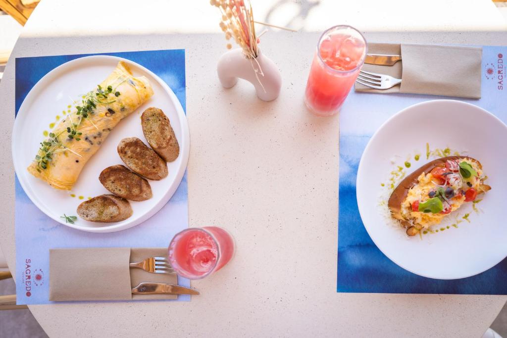 a table with a plate of food and a plate of potatoes at Sagredo Boutique Hotel & Spa in Ágios Fokás