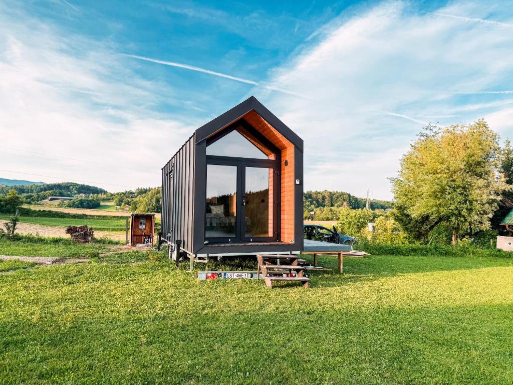 Šmartno v Rožni DoliniTiny House Glamping Mak的田野上有一扇大窗户的小房子