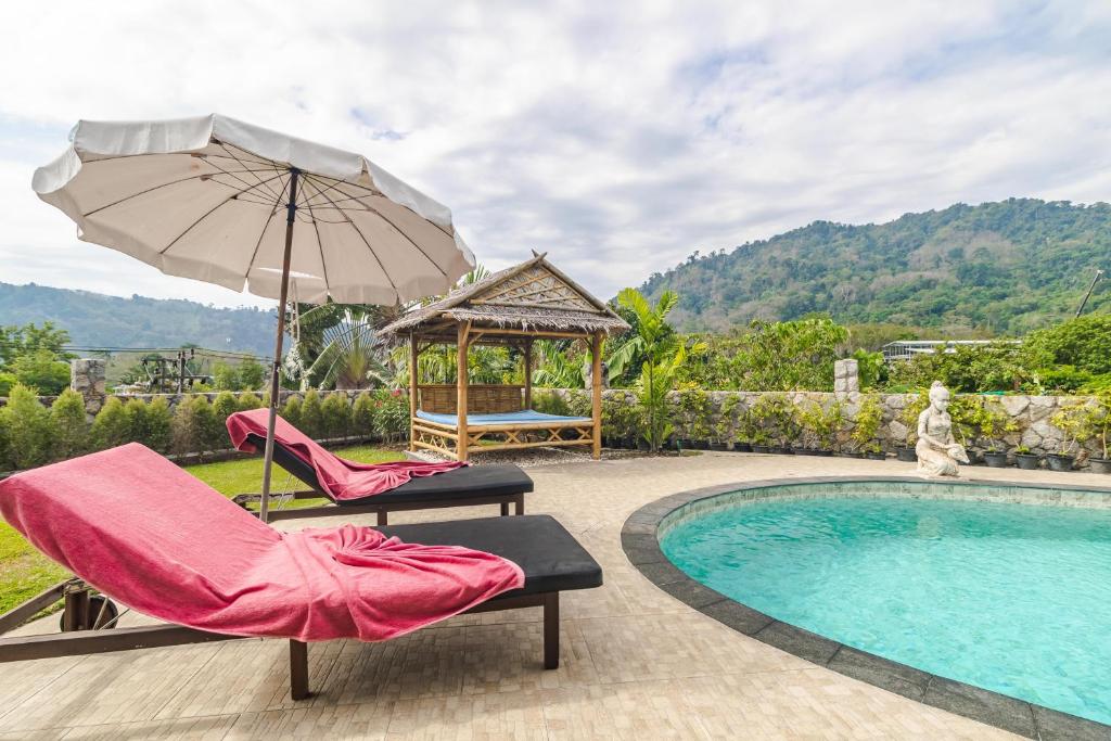 a pool with two chairs and an umbrella and a gazebo at Luxurious & Quiet Pool Villa Orchid in Nai Yang Beach