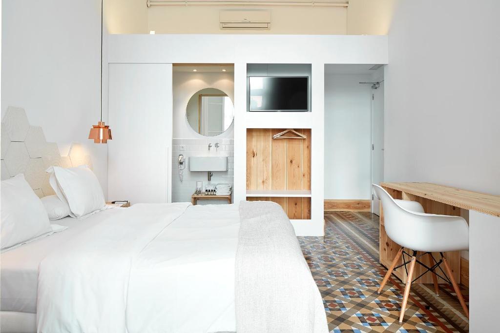 1 dormitorio con 1 cama blanca grande y escritorio en La Casa de Antonio Boutique Rooms en Barcelona