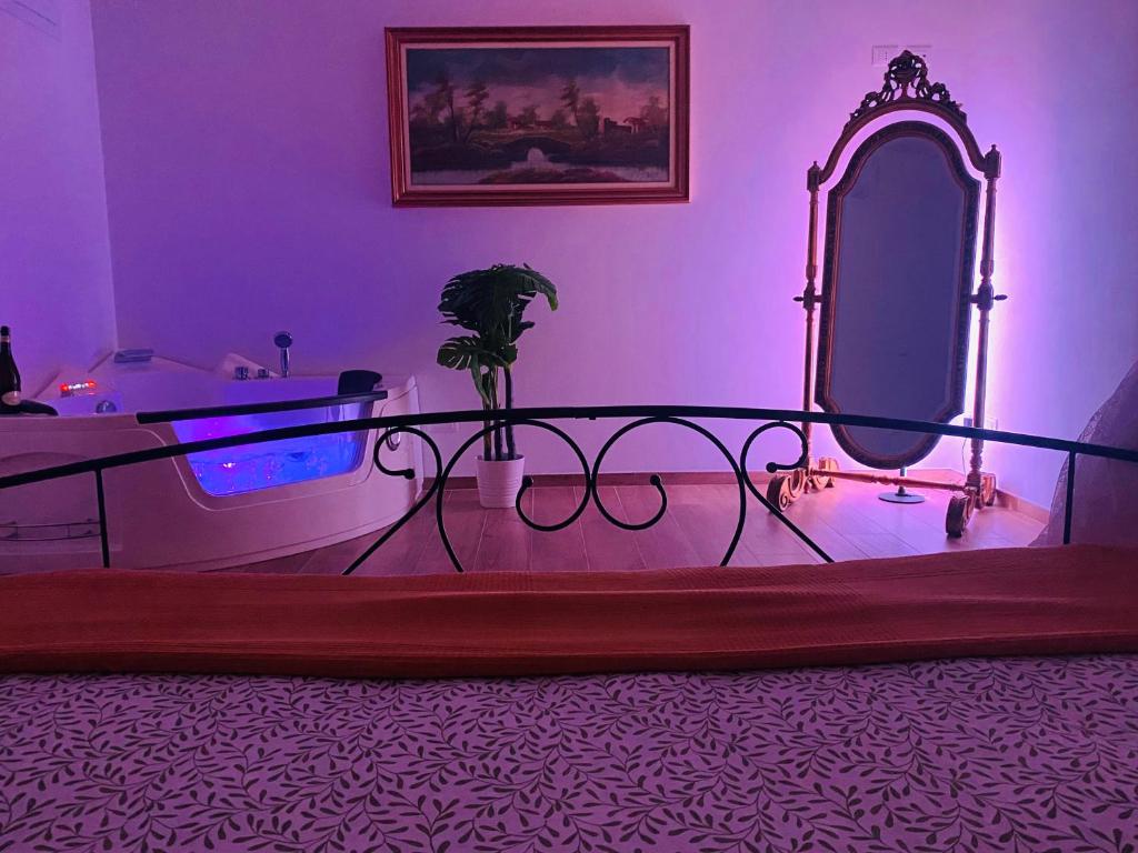 a bedroom with a bed with a mirror and purple lighting at Villa Alexander Suite esclusiva di 100 m con vasca idromassaggio in Trarivi