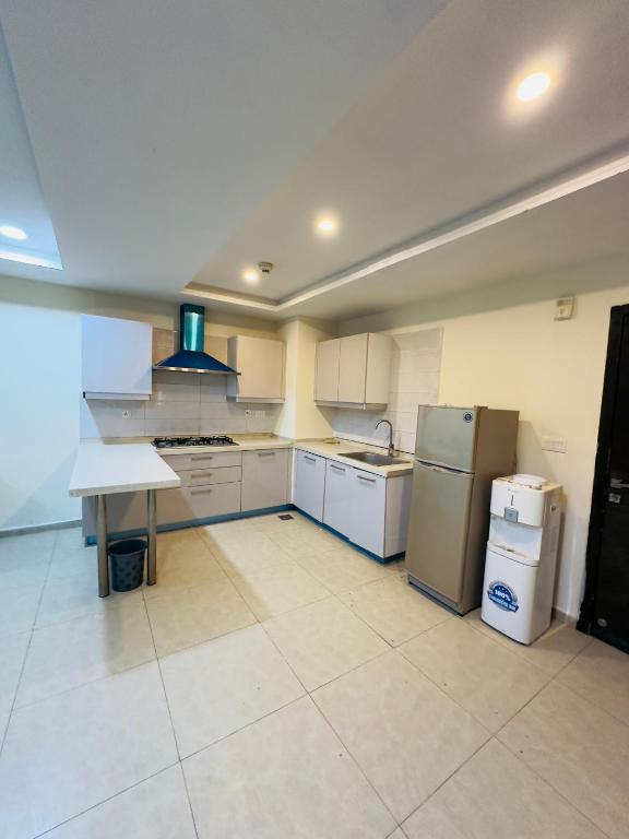 a large kitchen with white cabinets and appliances at Bahria Heights 1 in Dargai