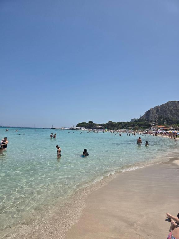 un gruppo di persone in acqua su una spiaggia di A pochi passi dal mare a Mondello