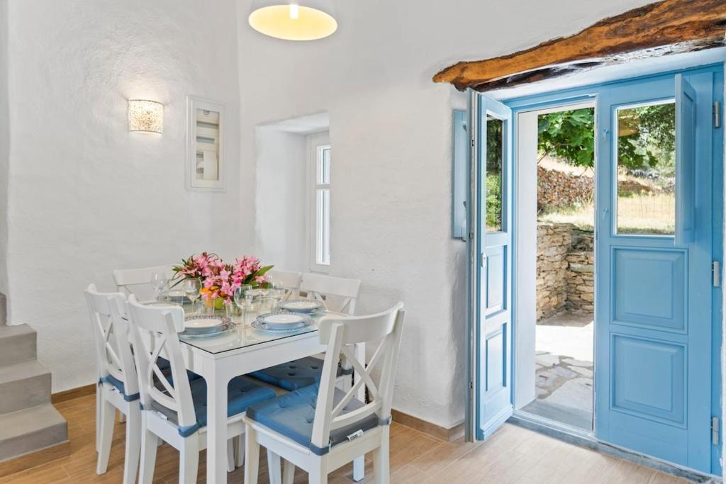 a white dining room with a white table and chairs at Peaceful Stay in Livadia, near Chora and Beach in Vrakhnós