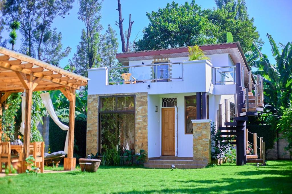 a small house with a green lawn at Tiny house with amazing view in Arusha