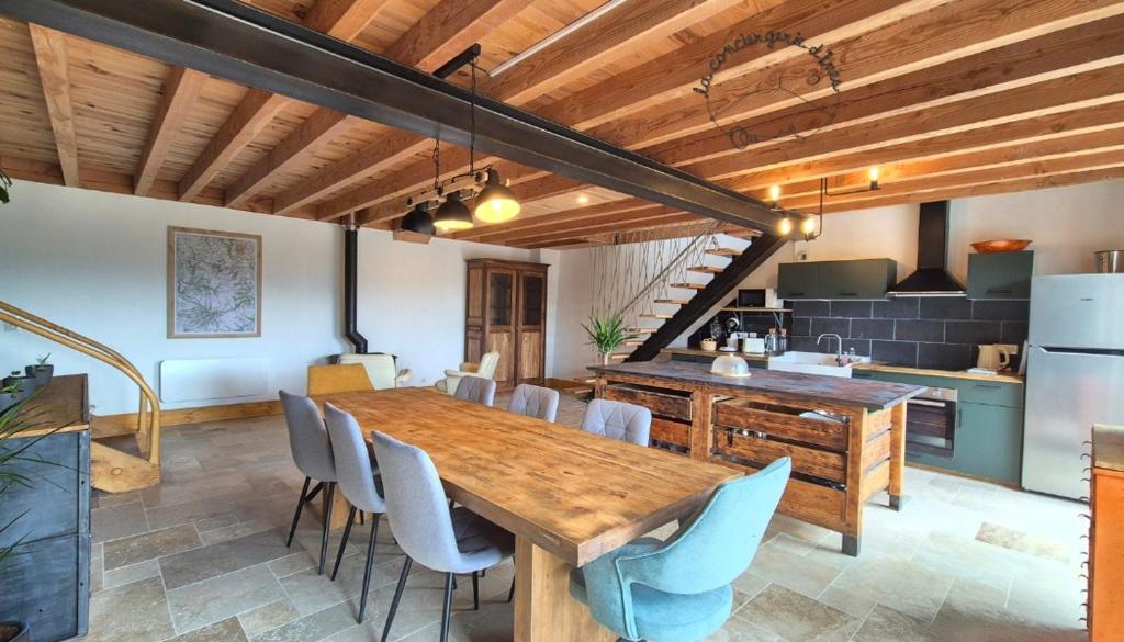 eine Küche und ein Esszimmer mit einem Holztisch und Stühlen in der Unterkunft Chez Bob - Grange de Charme in Olloix