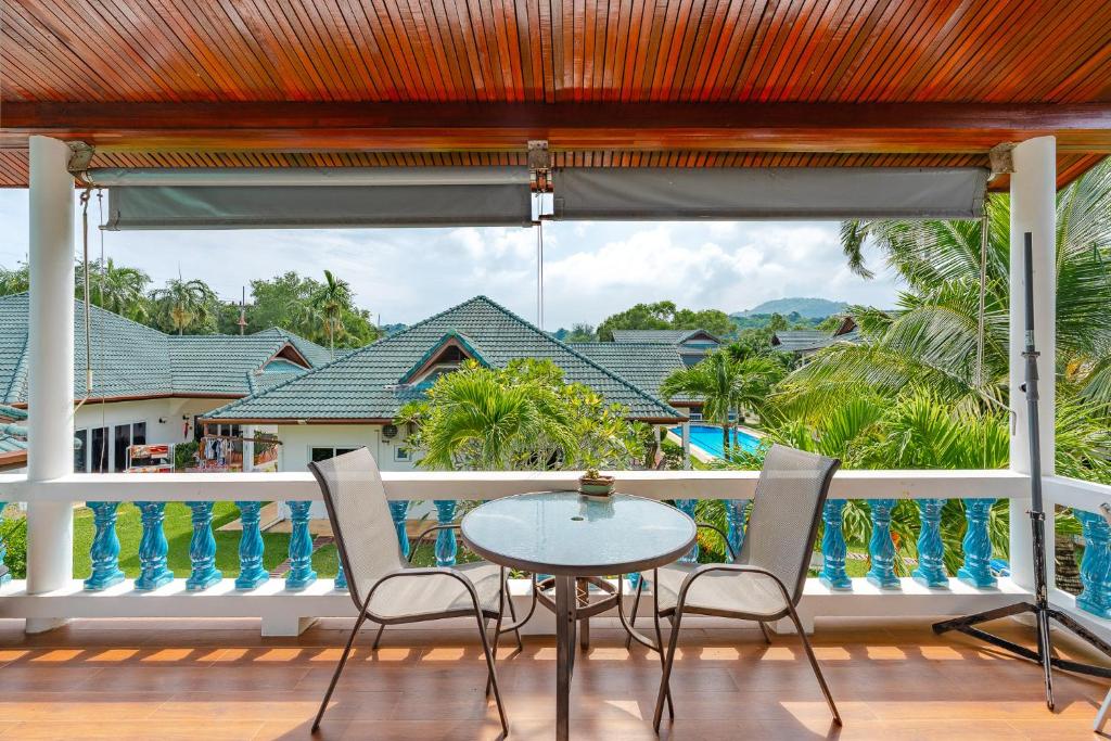 eine Terrasse mit Tisch und Stühlen auf einem Balkon in der Unterkunft V205 Island Hideaway Near Promthep Sunset in Nai Harn Beach