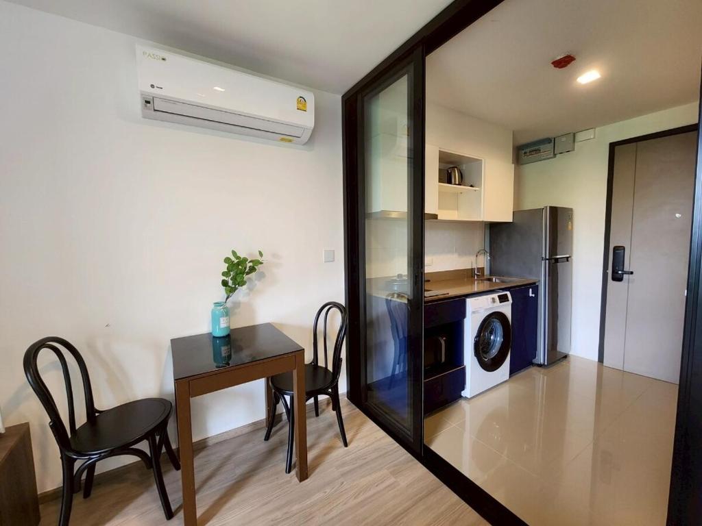 a kitchen and dining room with a table and a microwave at The Base Central Phuket-B32YJ in Ban Rangeng