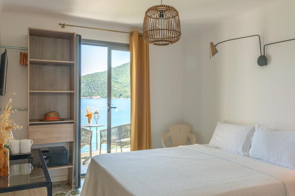 a bedroom with a bed and a view of the ocean at HOTEL CAMPOMORO in Belvédère-Campomoro
