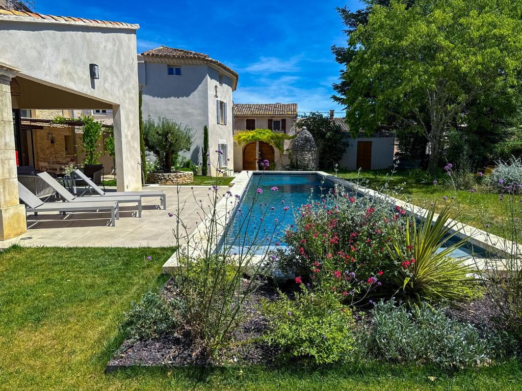 une cour arrière avec une piscine et une maison dans l'établissement La Magnanerie 1818 Luberon proche Gordes, Roussillon, à Saint-Saturnin-lès-Apt