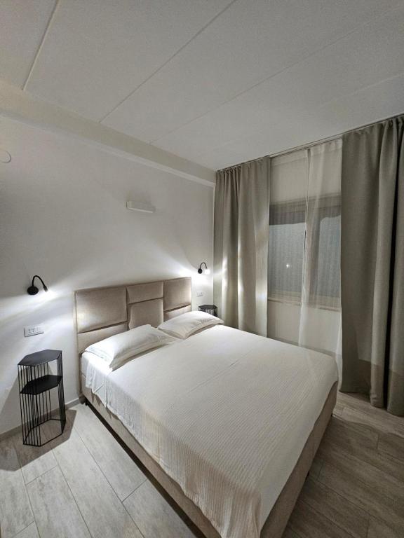 sypialnia z dużym białym łóżkiem i oknem w obiekcie Apartments Cocaletto5 w Rovinj