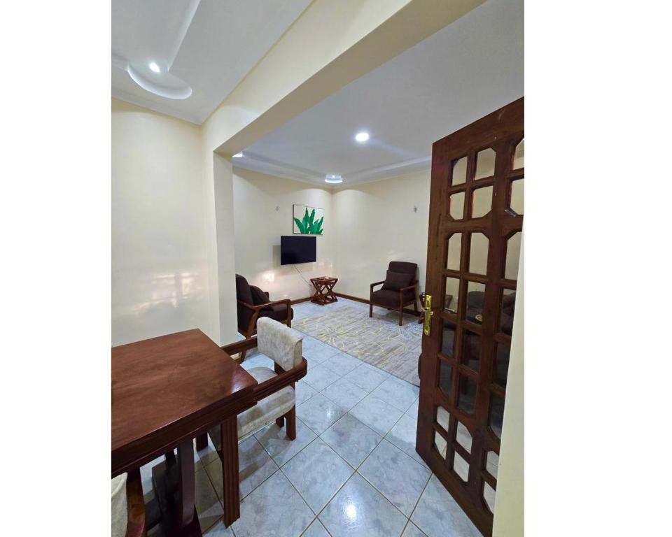 a living room with a wooden door and a living room at A private bedroom in a shared home in Arusha in Arusha