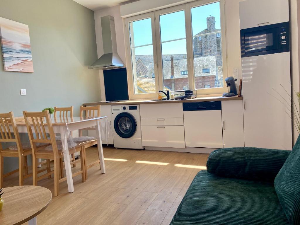 - un salon avec une cuisine et une table avec des chaises dans l'établissement L'éclat à trois pas de la mer, à Ault