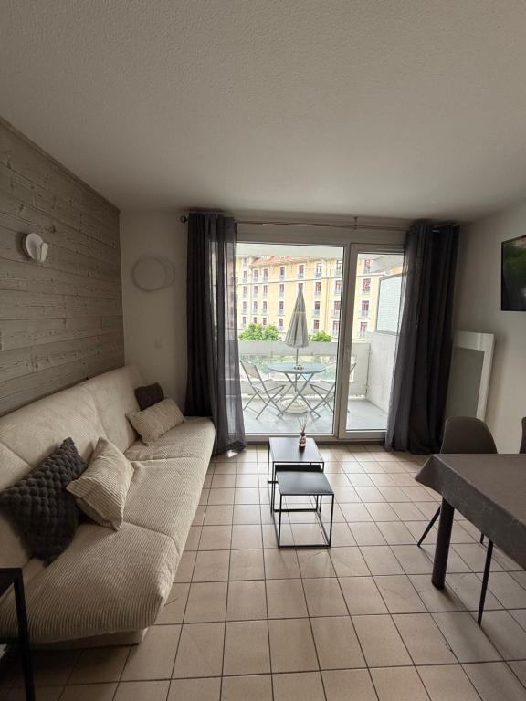 un salon avec un canapé et une table dans l'établissement Appartement cosy, à Allevard