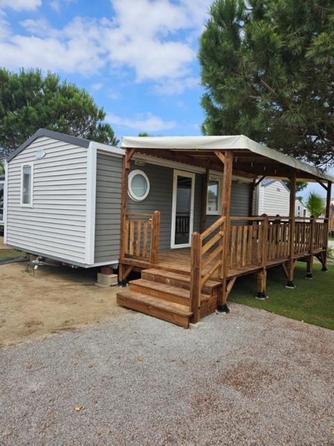 une petite maison avec un porche et une terrasse dans l'établissement Mobil home camping Marisol toreilles, à Torreilles