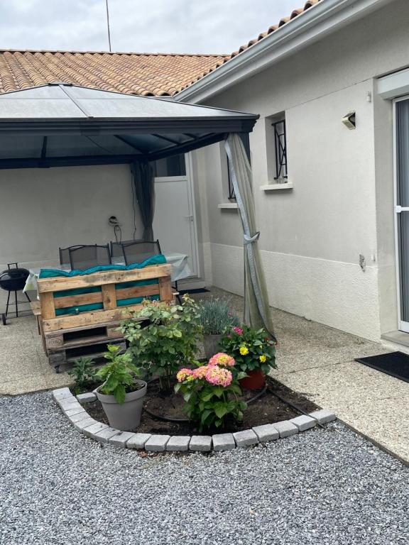 un patio avec un parterre et des fleurs dans un jardin dans l'établissement Les Oliviers, au Teich