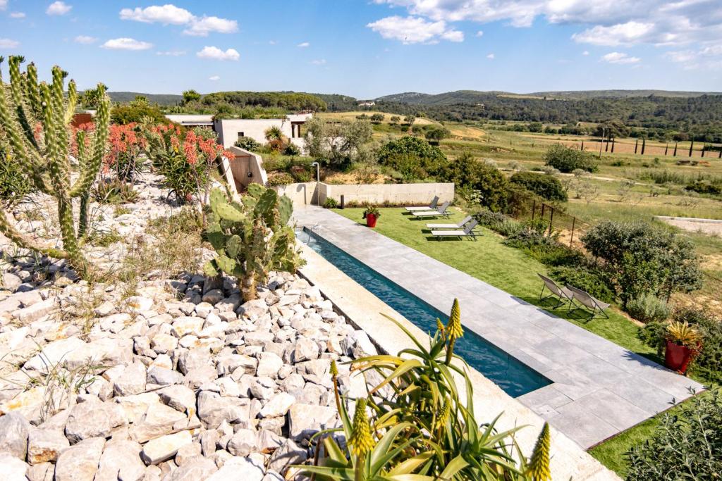 un jardín con una pared de piedra y una piscina en Gîte Mas Palat, en Gignac
