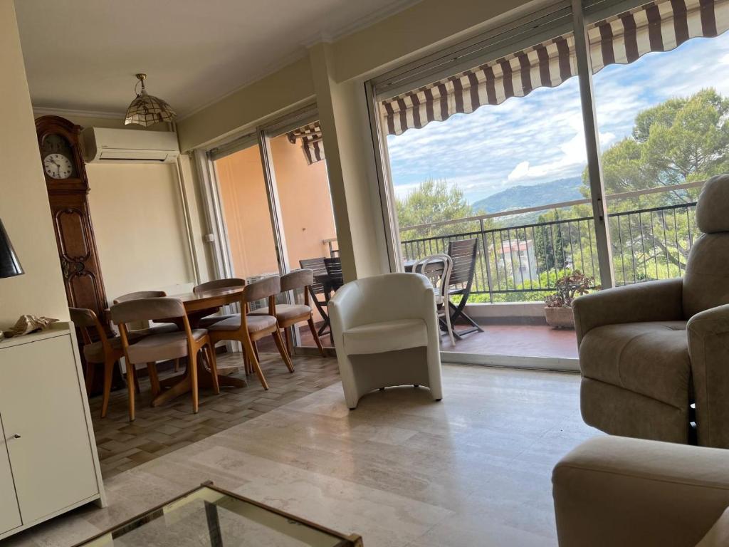un salon avec une table et des chaises et un balcon dans l'établissement Le Cannet Rocheville grand 3 pieces 2 terrasses, au Cannet