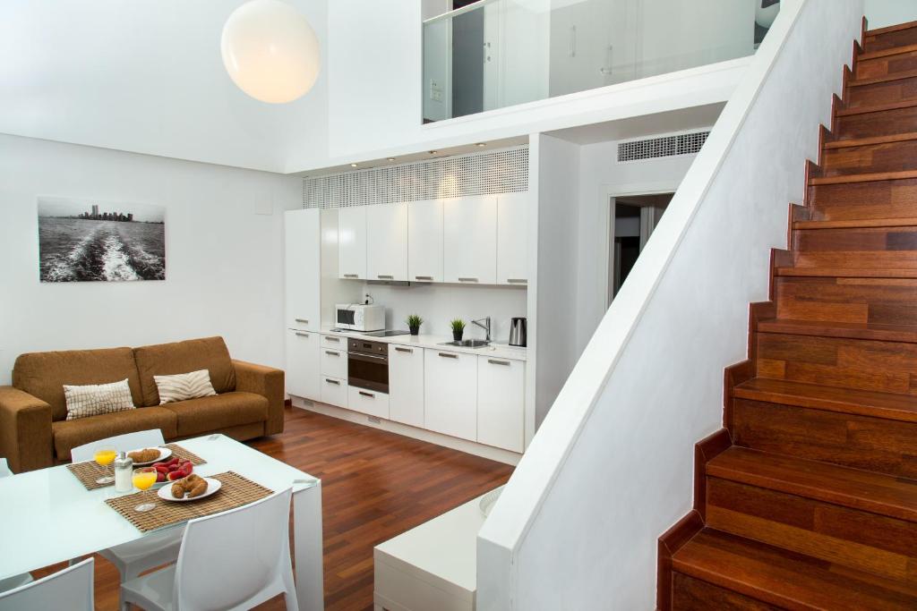 a kitchen and living room with a staircase in a house at Glasir Apartments Barcelona in Barcelona