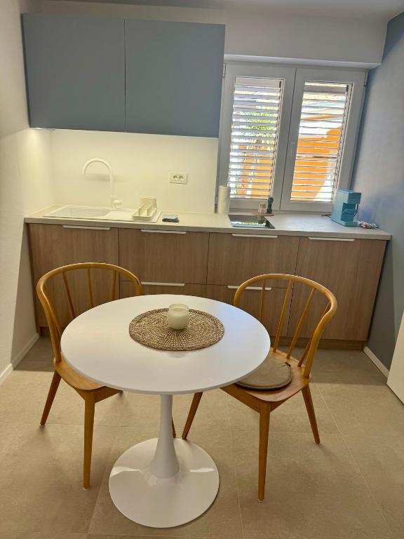 a white table and two chairs in a kitchen at Sunny Old Town Apartment in Koper