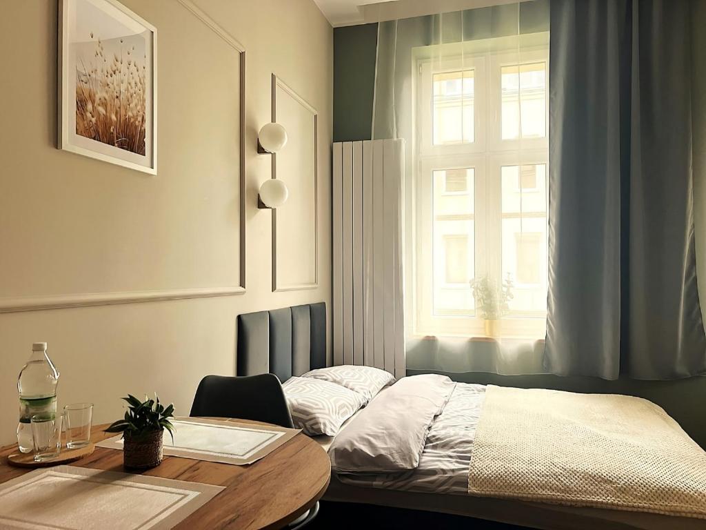 una camera da letto con un letto, un tavolo e una finestra di GREY Apartment 1 a Poznań