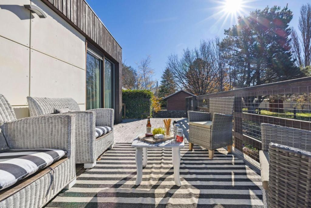 a patio with two wicker chairs and a table at Oliver Haus 4 Bedroom in Berridale