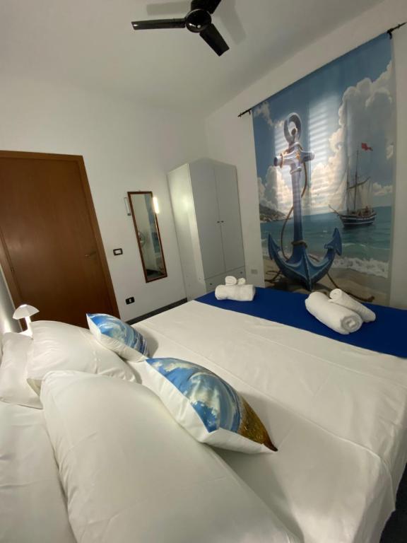 a bedroom with two beds with a painting on the wall at Vento a poppa in Porto Palo