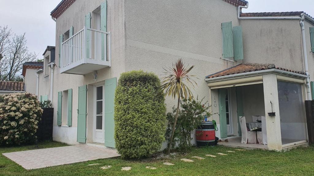 Cette maison blanche dispose de volets verts et d'une fenêtre. dans l'établissement Jolie maison au calme jardin plage a proximité, à Meschers-sur-Gironde