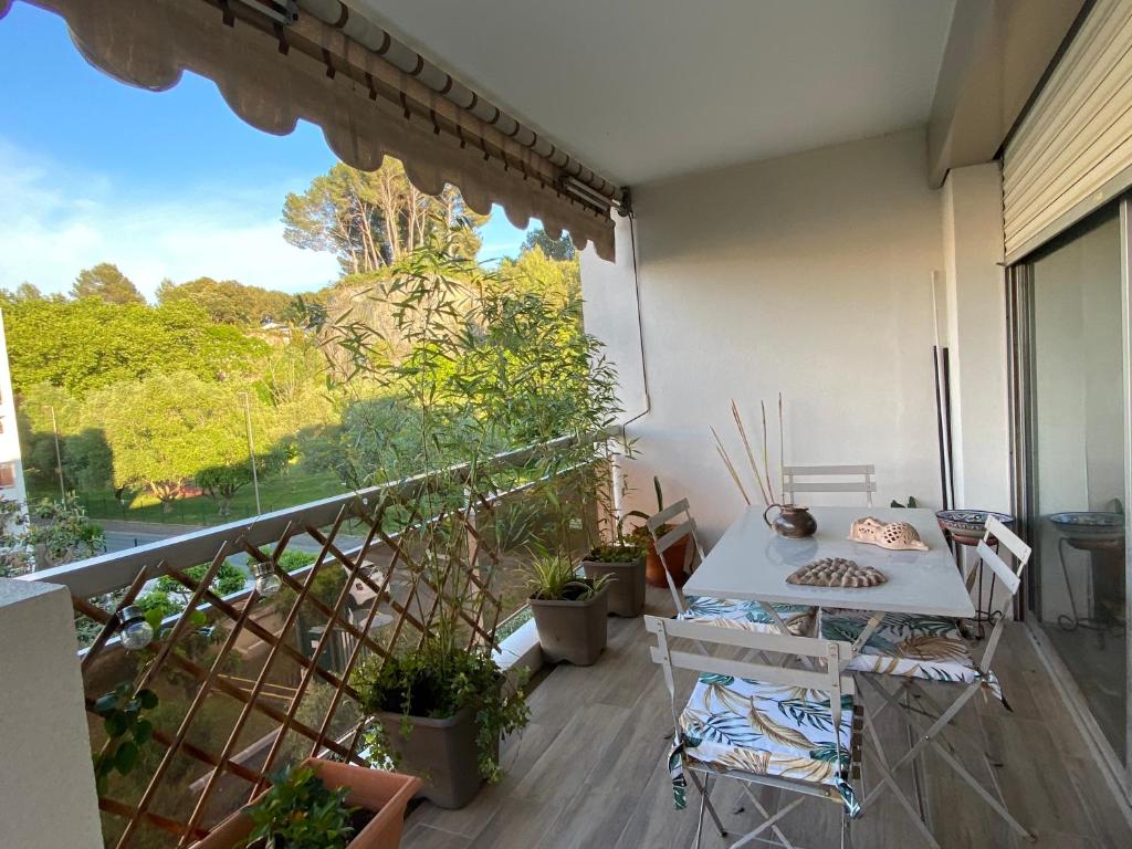 d'un balcon avec une table et quelques plantes. dans l'établissement Les Jades, au Cannet