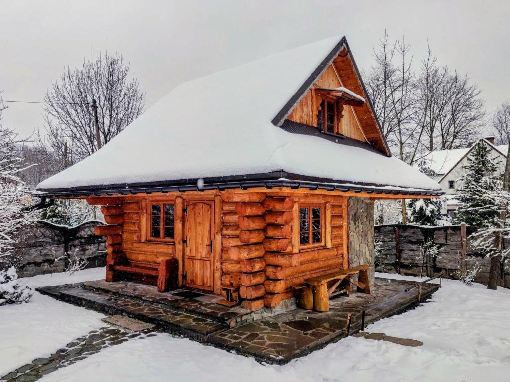 a log cabin with a snow covered roof at Domki na Skalistej w Szczyrku in Szczyrk