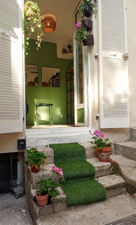 une maison avec des murs verts et des escaliers avec des plantes dans l'établissement A secret garden in Montmartre, à Paris