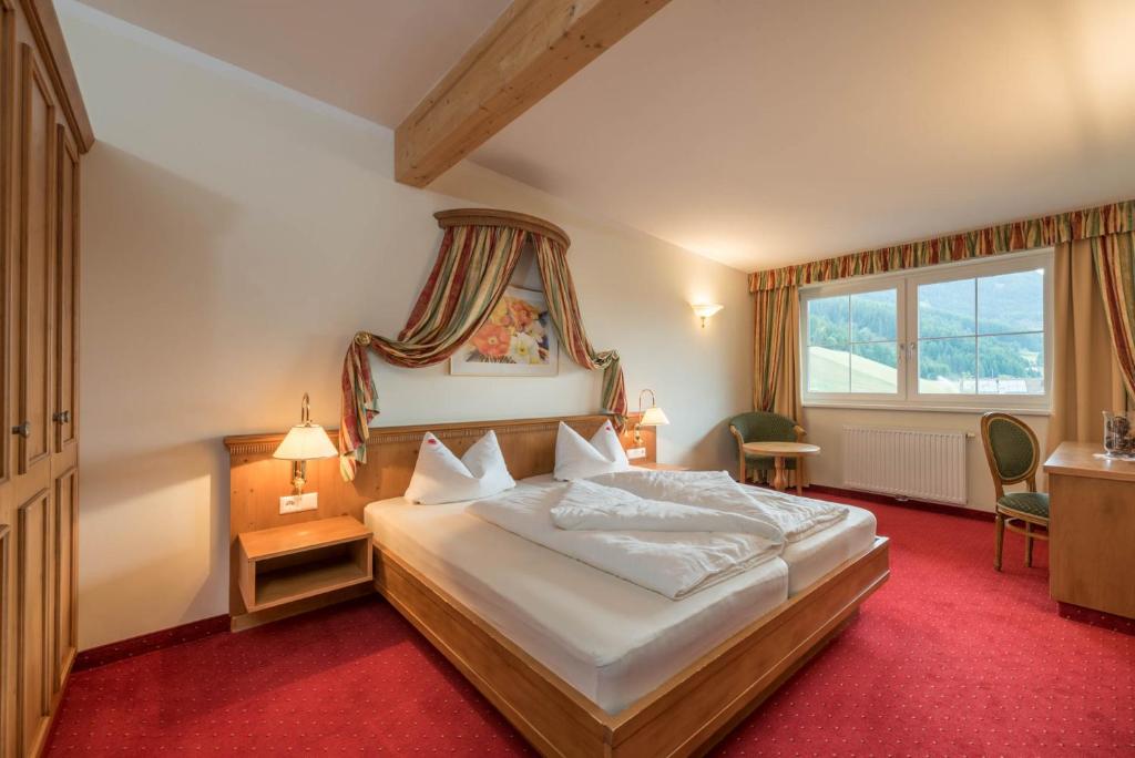 sypialnia z dużym łóżkiem i oknem w obiekcie Vital Hotel Ortlerspitz w mieście San Valentino alla Muta