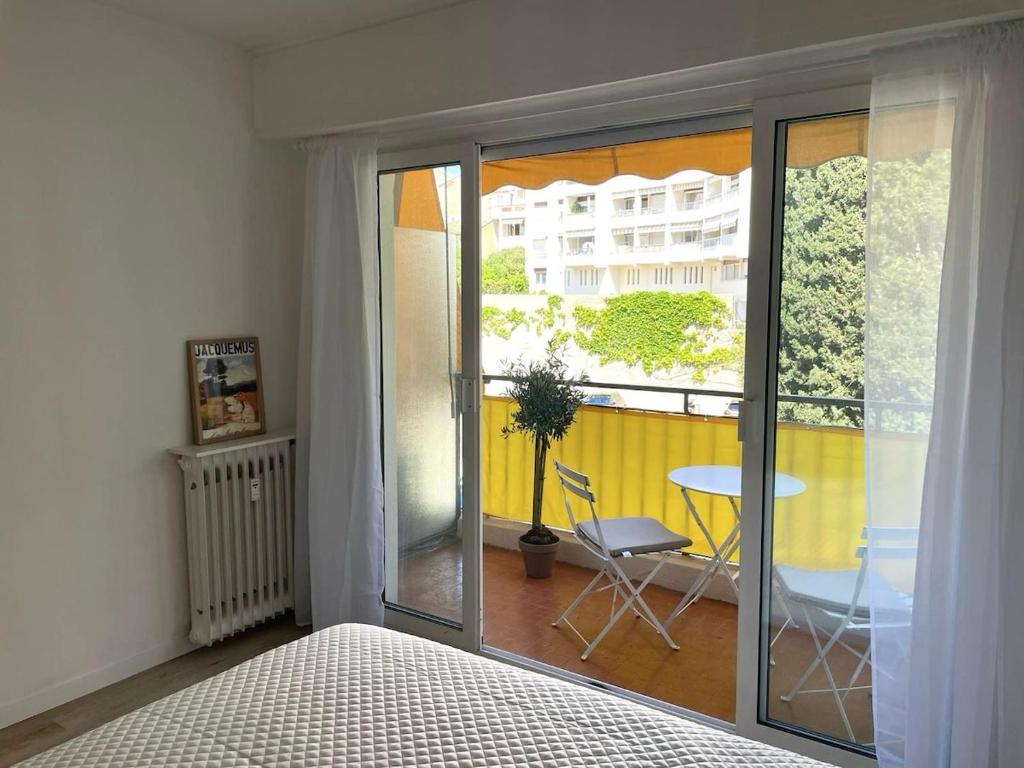 Cette chambre dispose d'un lit et d'un balcon avec une table. dans l'établissement Studio chic, Cannes Croisette 10 min, au Cannet