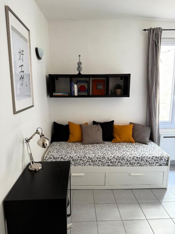 un lit dans une chambre avec un bureau noir dans l'établissement Au Carmes 1D joli T2 meublé et wifi, à Avignon