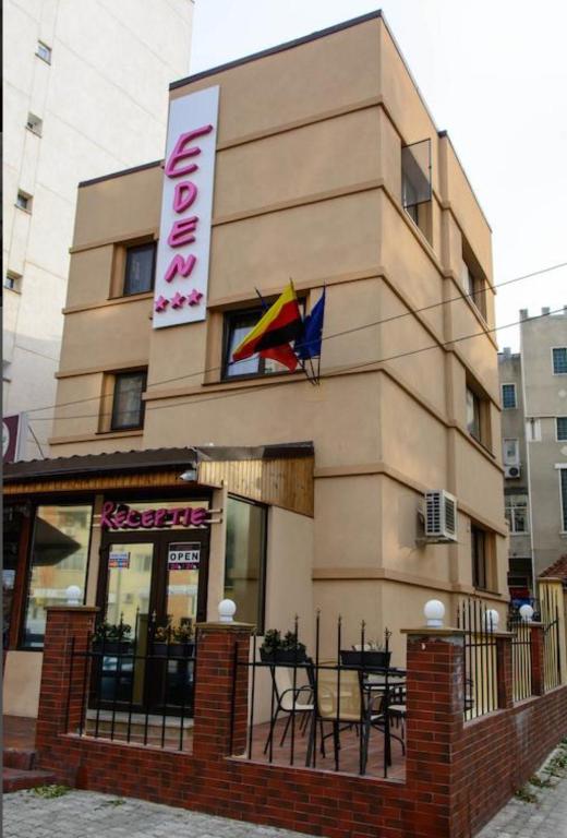 a building with a restaurant with a flag on it at Eden Boutique in Bucharest