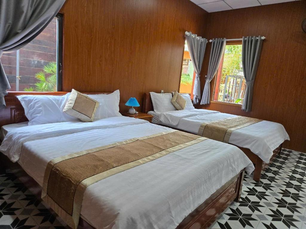 une chambre avec deux lits et une fenêtre dans l'établissement Homestay Nguyễn hưng, à Hue