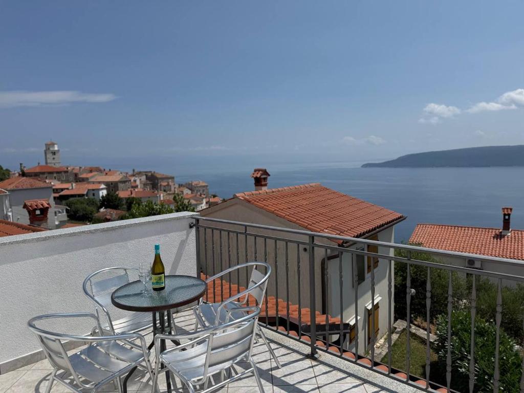 a table and chairs on a balcony with a view of the water at VILLA STASJA in Brseč