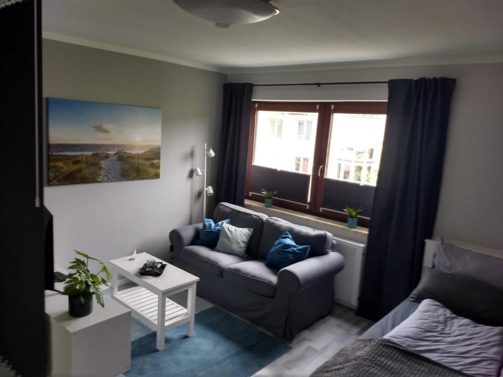 a living room with a couch and a window at City-Apartment in Bremerhaven in Bremerhaven