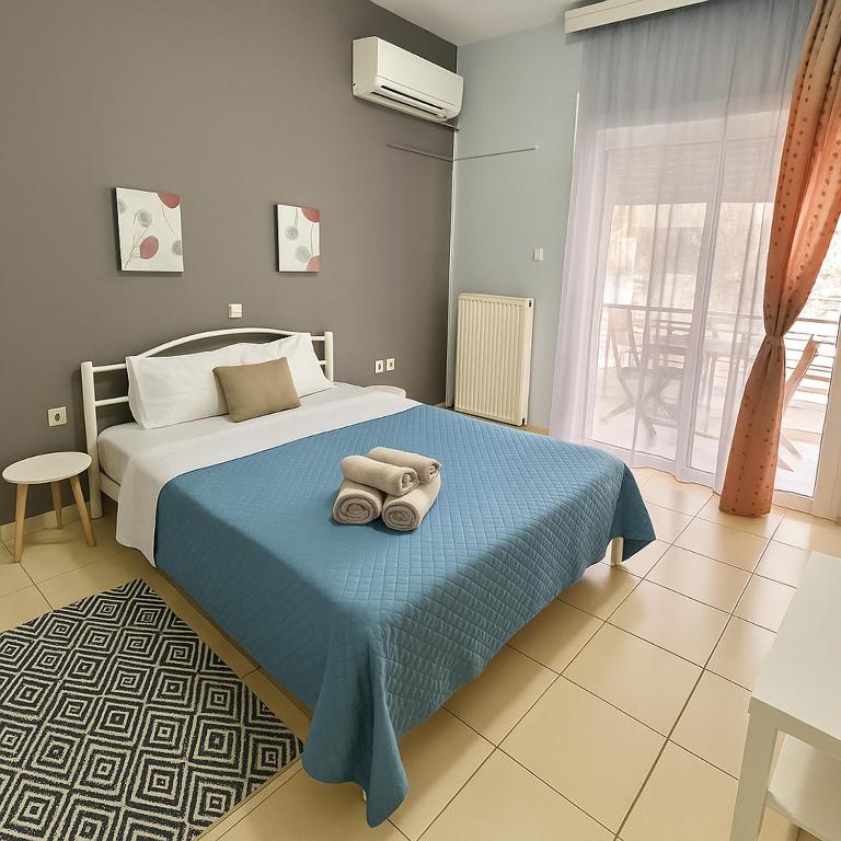 a bedroom with a bed with a blue blanket at Cozy apartment 3 in Serres