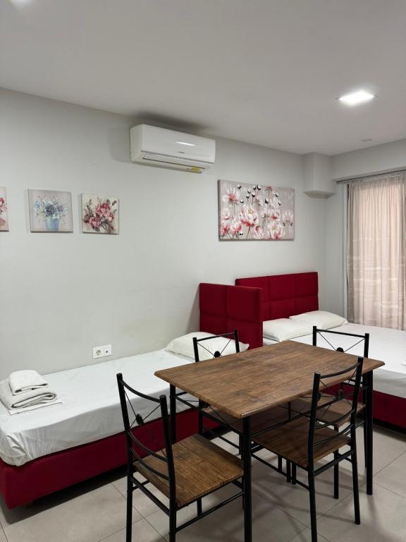 a room with two beds and a table and chairs at Milla Lux 3 in Paralia Katerinis