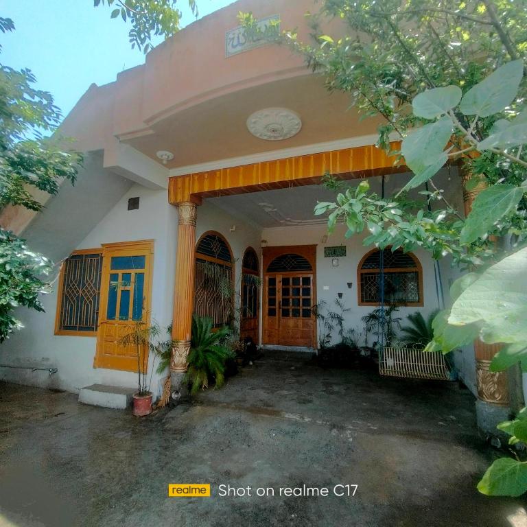 a house with a front porch and a door at Whispering Fields in Abbottabad