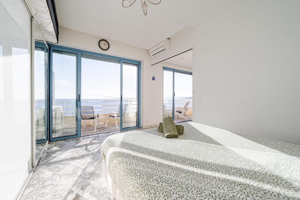 a bedroom with a large bed with a view of the ocean at Juan les pins, premium, sea view, sleeps 6 in Juan-les-Pins