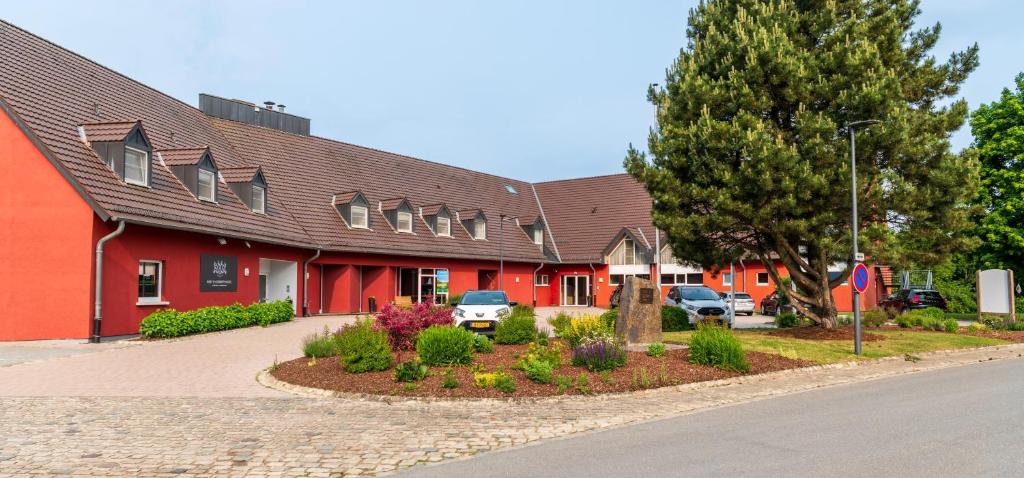 EselbornにあるL'Hôtel et Restaurant du Golf de Clervauxの車が目の前に停まった赤い建物