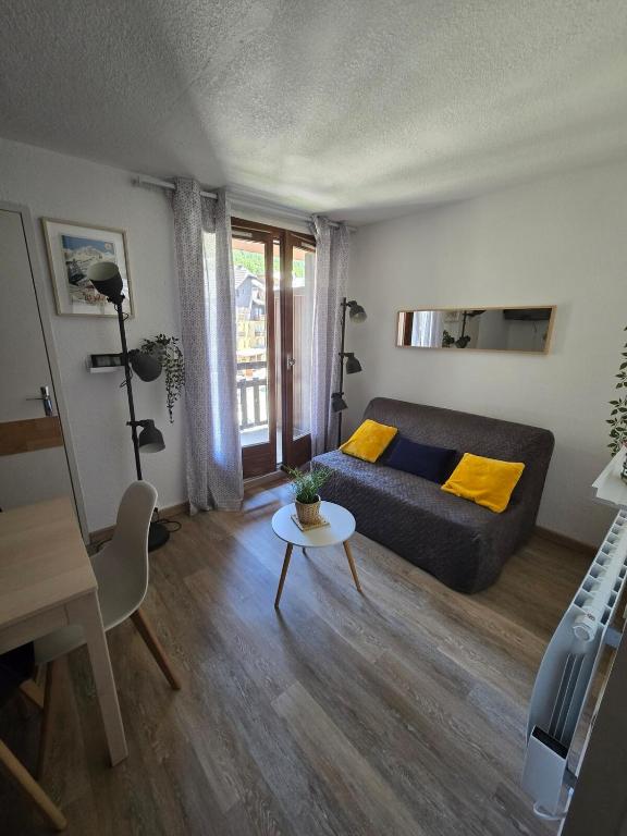un salon avec un canapé et une table dans l'établissement Appartement chaleureux, à Risoul