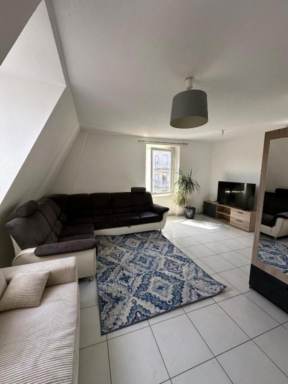 un salon avec un canapé et un tapis dans l'établissement Appart City, à Saint-Louis