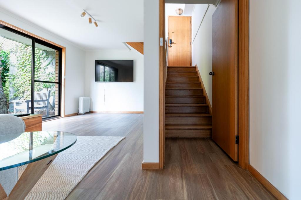 a living room with a staircase and a glass table at Bright and Beautiful Near the Gorge with Parking in Royal Park