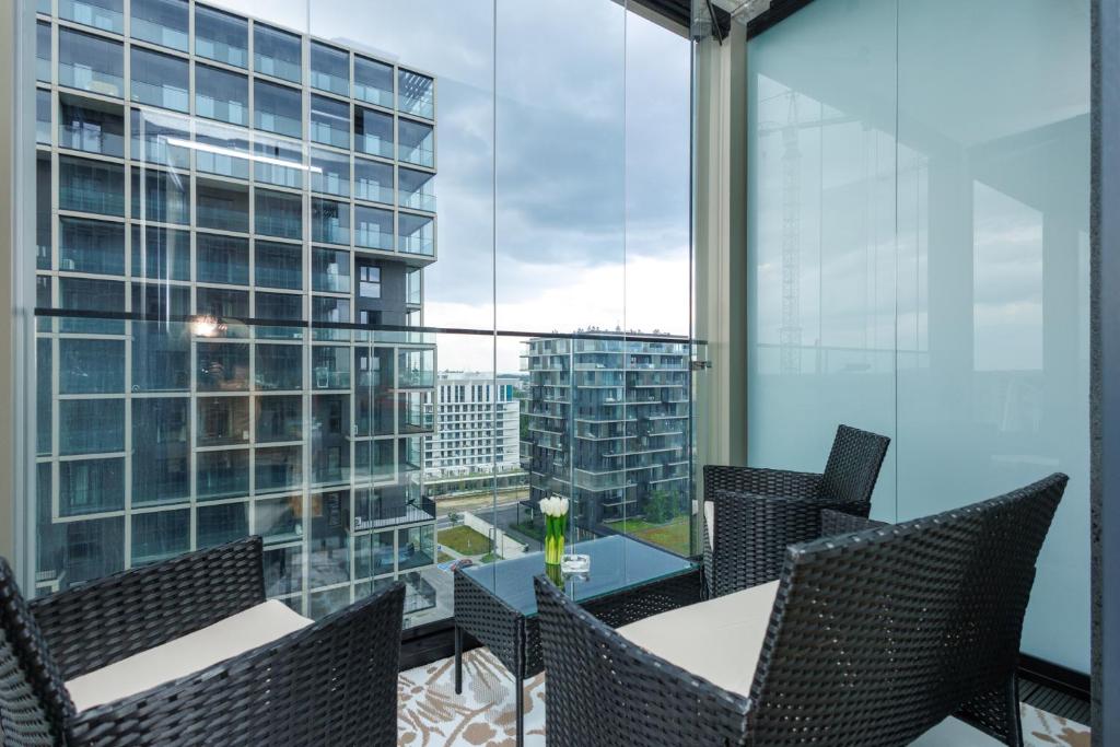 a balcony with a table and chairs and a large window at Katowice Spodek in Katowice