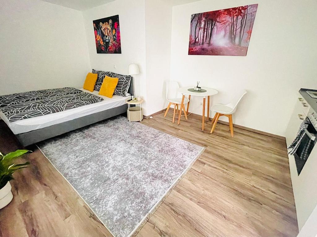 a bedroom with a bed and a table and chairs at Apartment in Zentrumsnähe NETFLIX SELF CHECK-IN in Augsburg
